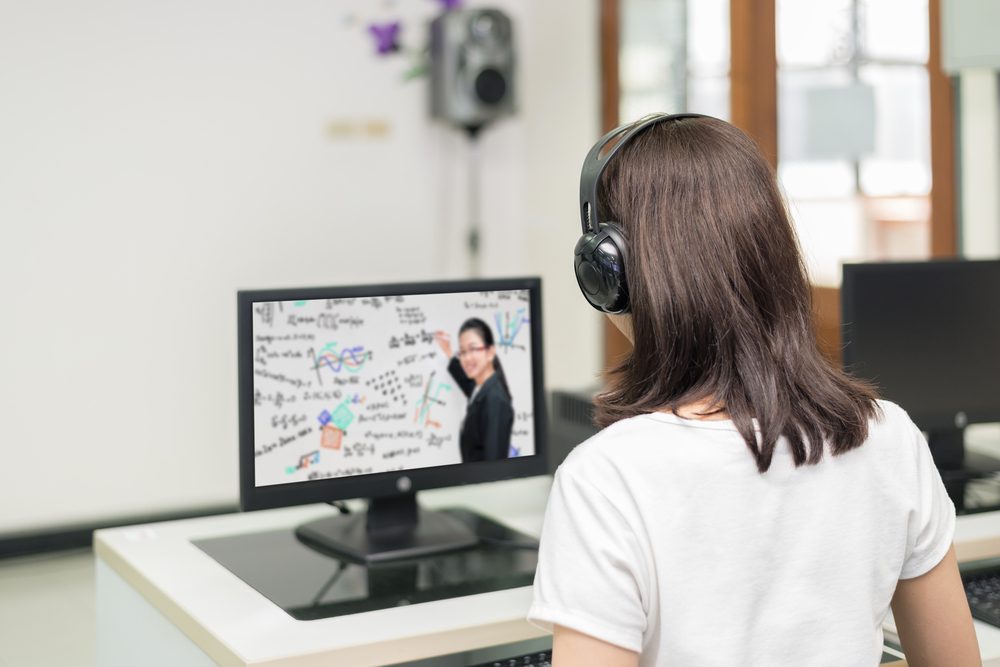 Um mulher assiste uma videoaula em frente ao computador. A imagem figura o tema do artigo sobre a importância da plataforma de vídeos