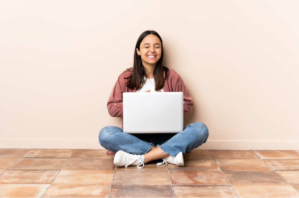 Na imagem, uma garota por volta de 13 anos está sentada no chão com um laptop em suas pernas. Essa imagem foi usada para ilustrar a mudança da persona do estudante em cada fase do ensino e como isso modifica a escolha dos objetos digitais de aprendizagem.